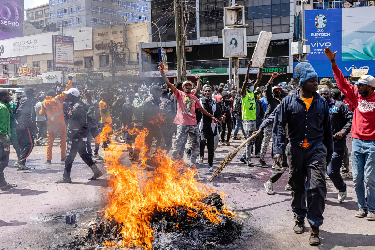 Protesters react next to burning tires during a protest against the finance bill in Nairobi, Kenya, on June 25, 2024. (Patrick Meinhardt/Getty Images)