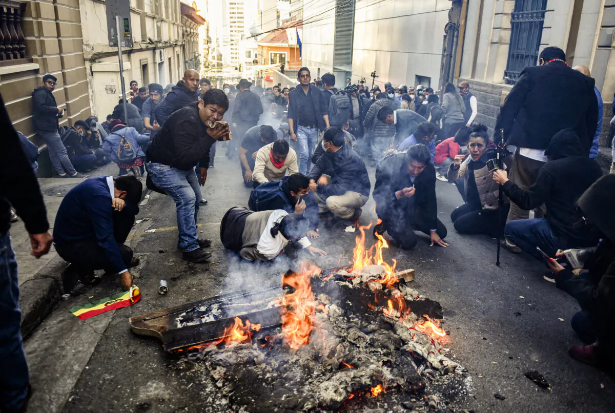 Demonstrators lay down while facing members of Bolivia's military as Bolivia's President Luis Arce "denounced the irregular mobilization" of some units of the country's army in La Paz, Bolivia, on June 26, 2024. (REUTERS/Claudia Morales)