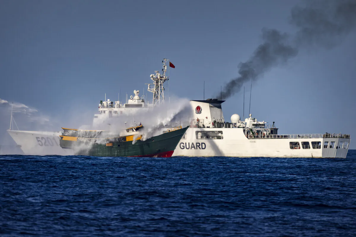 A Chinese coast guard ship fires a water cannon at Unaizah, a Philippine navy chartered vessel conducting a routine resupply mission to troops stationed at Second Thomas Shoal, in the South China Sea on March 5, 2024. (Ezra Acayan/Getty Images)