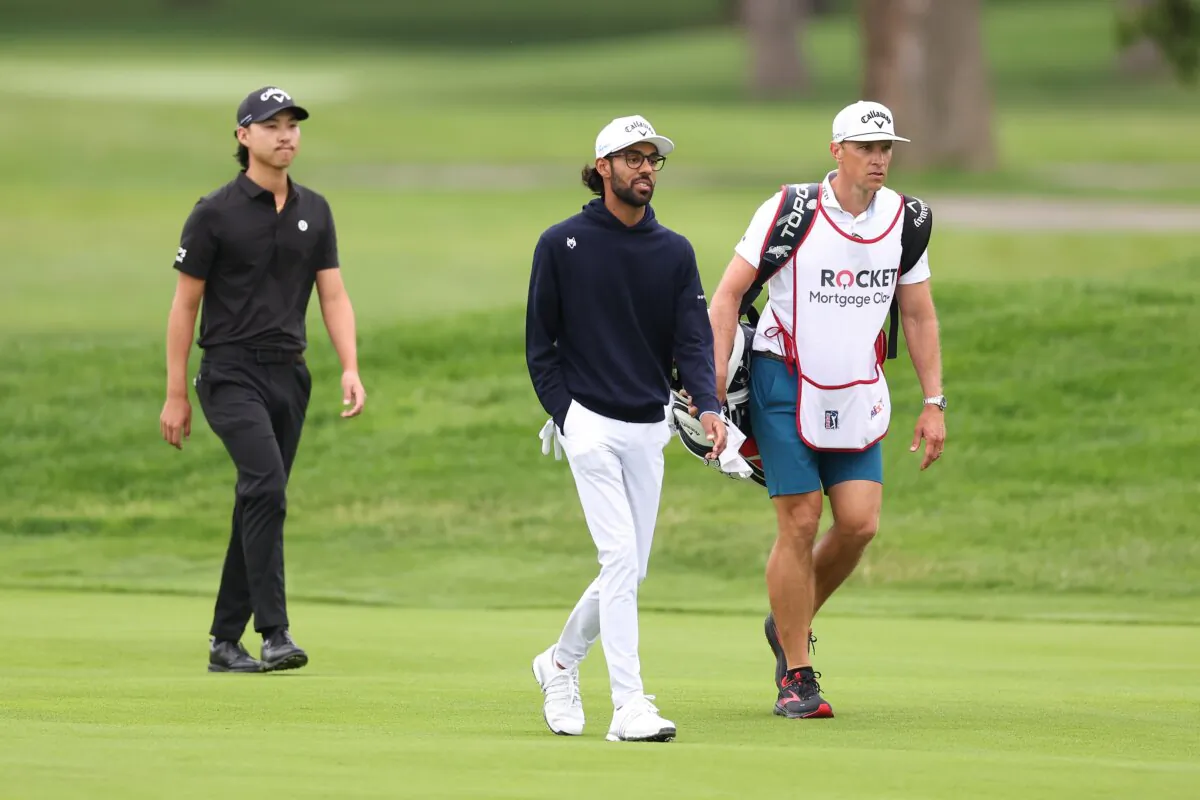 Akshay Bhatia of the United States along with caddie and Min Woo Lee of Australia, walk up the 17th hole during the second round of the Rocket Mortgage Classic  in Detroit on June 28, 2024. (Gregory Shamus/Getty Images)