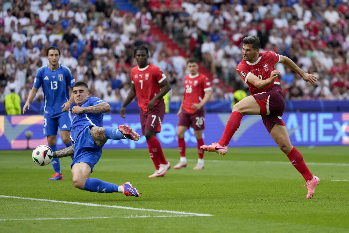 Switzerland's Remo Freuler (R) shoots and scores past Italy's Gianluca Mancini during a round of sixteen match between Switzerland and Italy at the Euro 2024 soccer tournament in Berlin, Germany, on June 29, 2024. (Matthias Schrader/AP Photo)