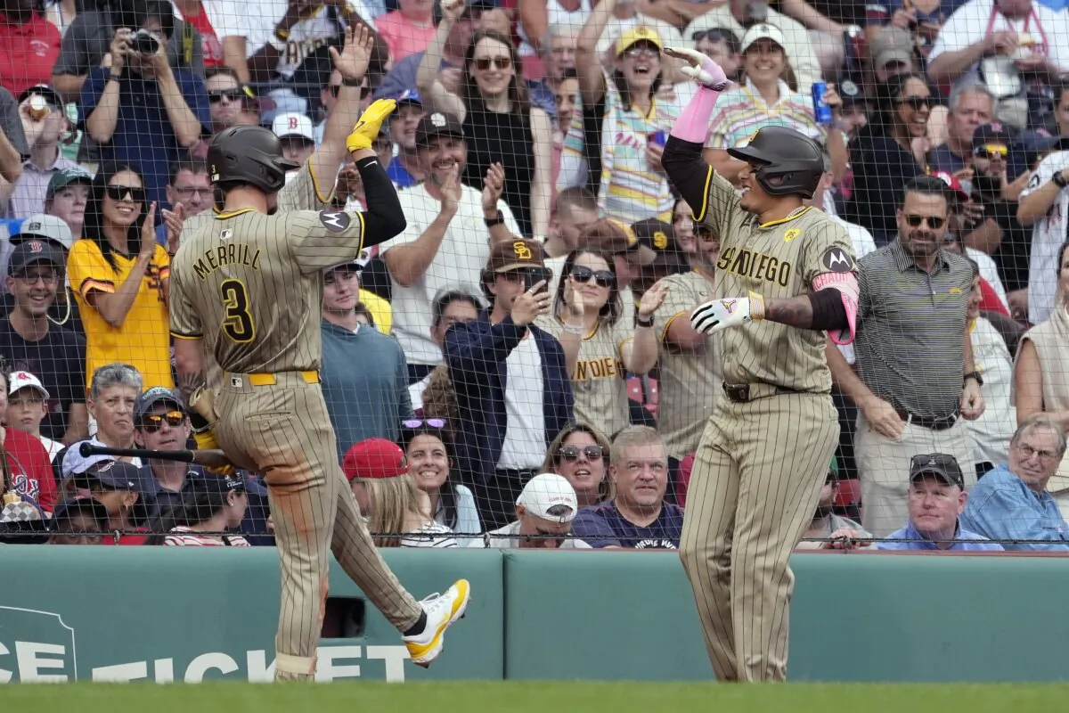 San Diego Padres' Manny Machado, right, celebrates with Jackson Merrill (3) after hitting a two-run home run during the third inning of a baseball game against the Boston Red Sox, Saturday, June 29, 2024, in Boston. (AP Photo/Michael Dwyer)