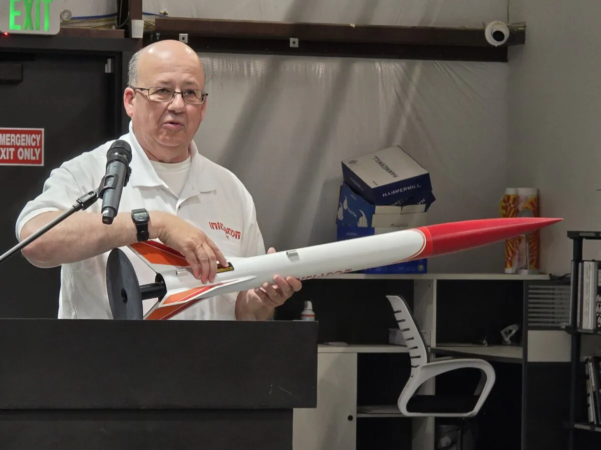 Bob Sanford, designer of the AeroTech "Initiator" model rocket, displays an actual version during the grand opening of RCS Rocket Motor Components' new world headquarters and museum to hobby rocketry in Cedar City, Utah, on June 27, 2024. (Allan Stein/The Epoch Times)