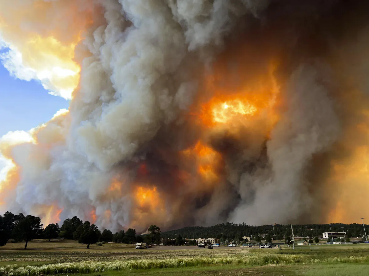 In this photo provided by Pam Bonner, smoke rises from fires in Ruidoso, N.M., on June 17, 2024. Thousands of southern New Mexico residents fled the mountainous village as a wind-whipped wildfire tore through homes and other buildings. (Pam Bonner via AP)