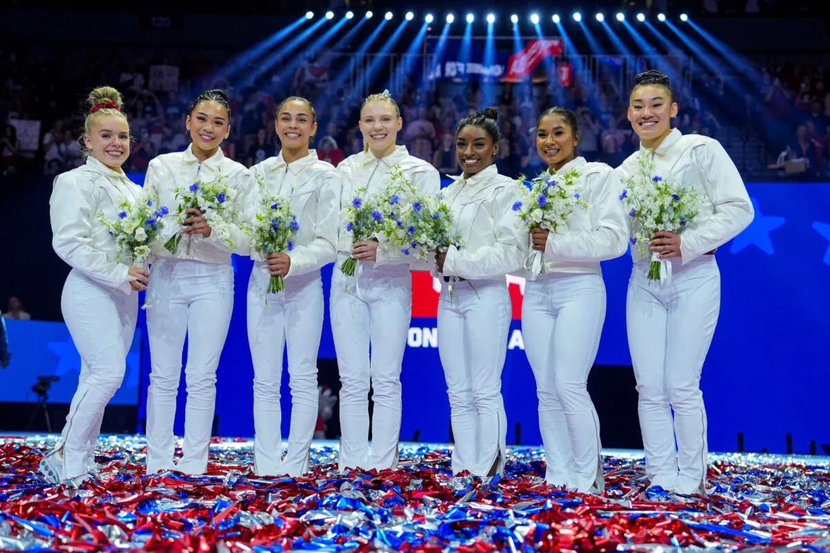 (L–R) Joscelyn Roberson, Suni Lee, Hezly Rivera, Jade Carey, Simone Biles, Jordan Chiles, and Leanne Wong smile after they were named to the 2024 Olympic team at the United States Gymnastics Olympic Trials in Minneapolis on June 30, 2024 (Charlie Riedel/AP Photo)
