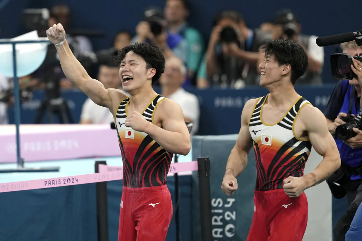 Shinnosuke Oka, left, and Daiki Hashimoto, of Japan, right, celebrate after Oka won the gold medal during the men's artistic gymnastics all-around finals in Bercy Arena at the 2024 Summer Olympics, Wednesday, July 31, 2024, in Paris, France. (AP Photo/Francisco Seco)