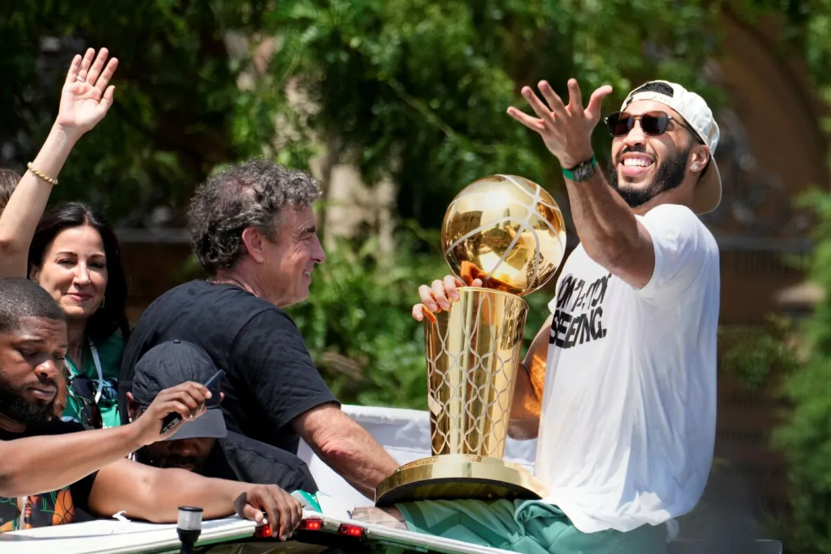 Boston Celtics owner Wyc Grousbeck (C) and star forward Jayson Tatum celebrate their NBA championship during a duck boat parade in Boston on June 21, 2024. (Michael Dwyer/AP Photo)