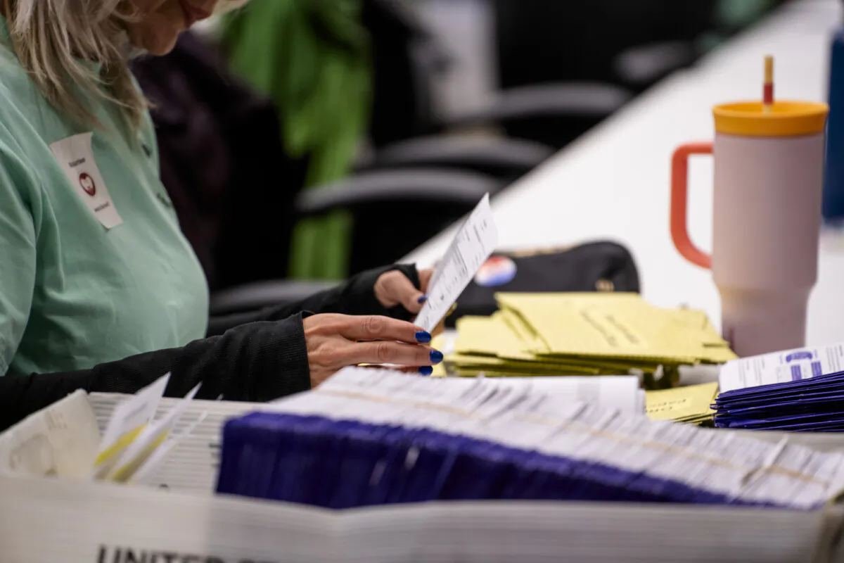An election volunteer prepares mail-in ballots for scanning at the Lancaster County Government Center in Lancaster, Pa., on April 23, 2024. (Madalina Vasiliu/The Epoch Times)