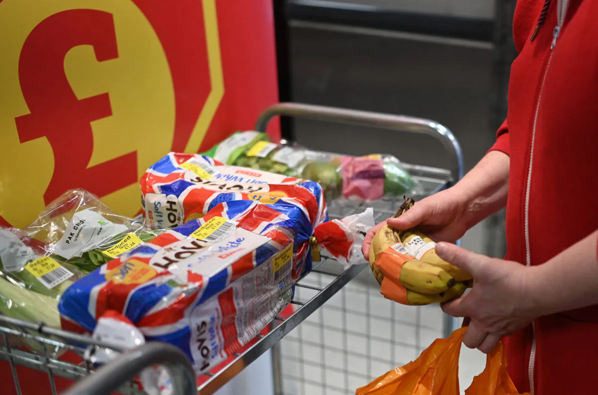 A woman holds a bunch of bananas inside a supermarket in east London on May 9, 2024. (Justin Tallis/AFP via Getty Images)