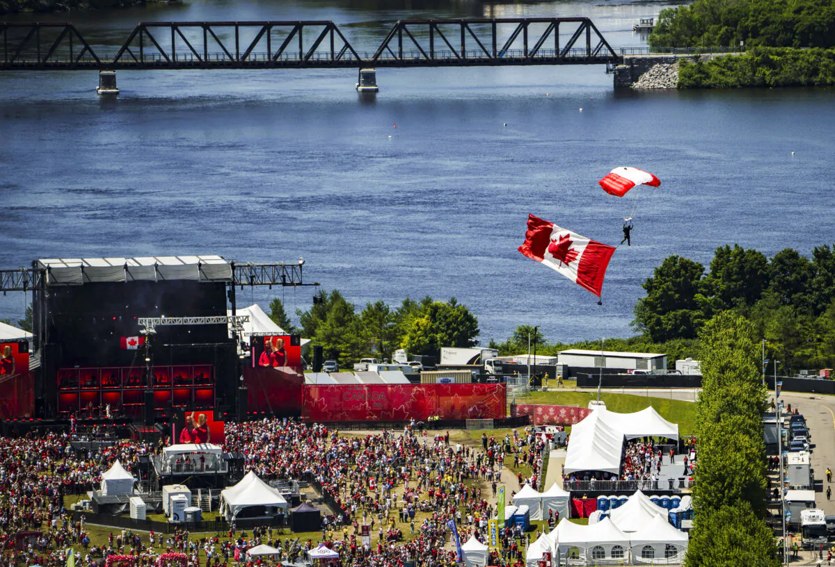 A member of the Skyhawks Parachute Team floats above the Canada Day noon hour show during a flypast celebrating the RCAF centennial, at LeBreton Flats in Ottawa on July 1, 2024. (The Canadian Press/Justin Tang)