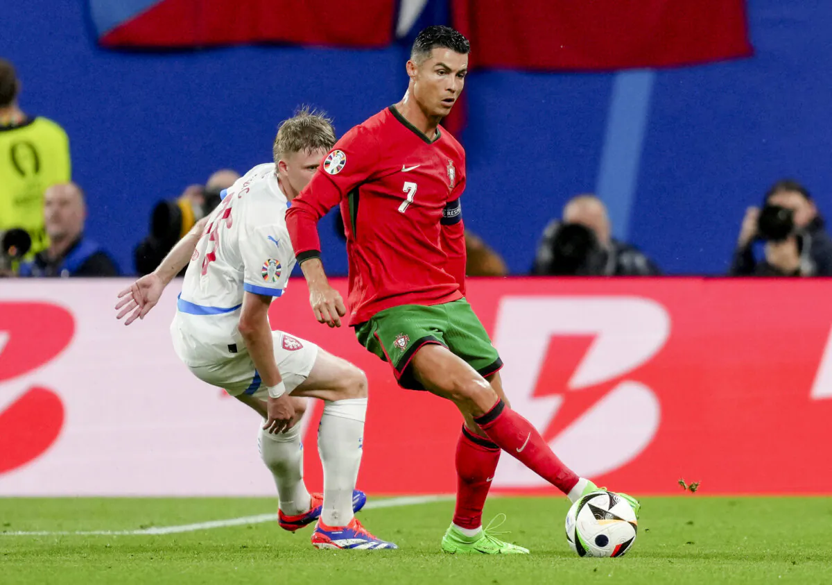 Portugal's Cristiano Ronaldo (R), and Czech Republic's David Jurasek challenge for the ball during a Group F match between Portugal and Czech Republic at the Euro 2024 soccer tournament in Leipzig, Germany, on June 18, 2024. (Sunday Alamba/AP Photo)