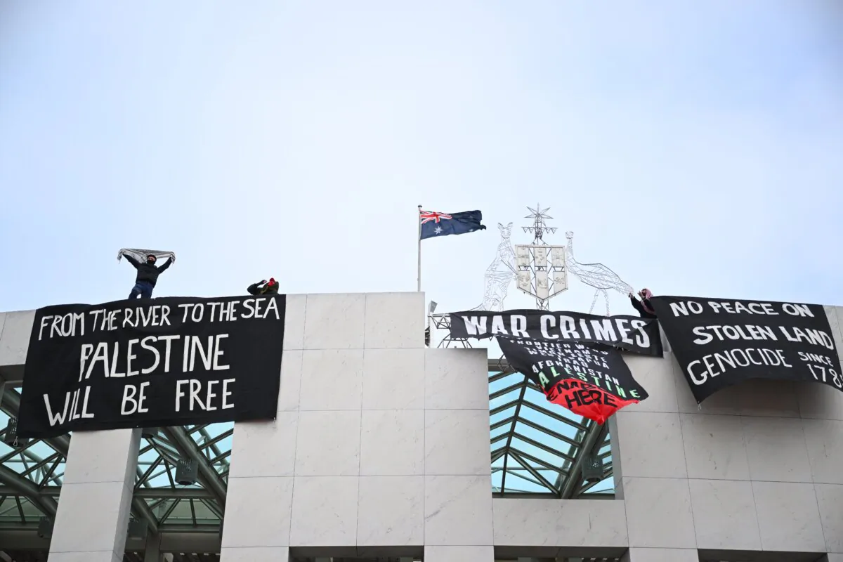 Radical pro-Palestine protesters hang banners from the top of Parliament House in Canberra, Australia on July 4, 2024. (AAP Image/Lukas Coch)