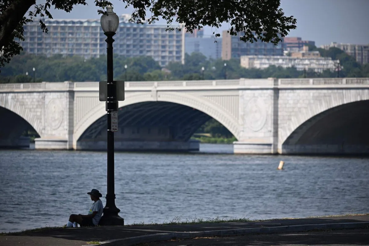 A man sits in the shade next to the Potomac River during a hot day in Washington, D.C., on Sept. 7, 2023. (Mandel Ngan /AFP via Getty Images)