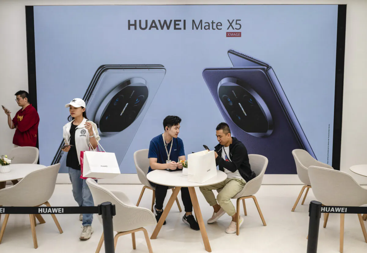 A customer speaks with a clerk as he picks up a new Mate 60 smartphone at a Huawei flagship store after the company unveiled new products in Beijing, China, on Sept. 25, 2023. (Kevin Frayer/Getty Images)