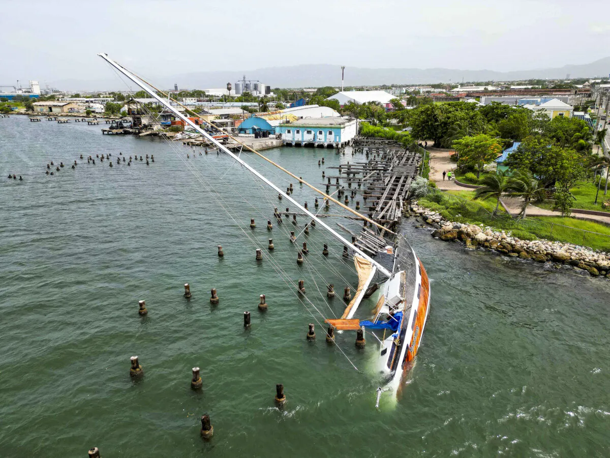 A boat damaged by Hurricane Beryl lays on its side at a dock in Kingston, Jamaica, on July 4, 2024. (Leo Hudson/AP Photo)
