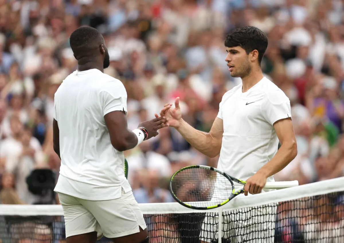 Carlos Alcaraz of Spain (R) meets Frances Tiafoe of United States at the net following victory in his Gentlemen's Singles third round match during day five of The Championships Wimbledon 2024 at All England Lawn Tennis and Croquet Club in London on July 5, 2024. (Julian Finney/Getty Images)