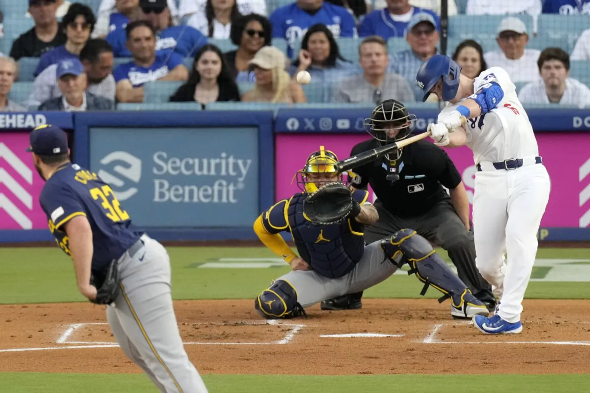 Los Angeles Dodgers' Will Smith (R) hits a solo home run as Milwaukee Brewers starting pitcher Aaron Civale (L) and catcher William Contreras, watch along with home plate umpire Brian Walsh during the first inning of a baseball game in Los Angeles on July 5, 2024. (Mark J. Terrill/AP Photo)