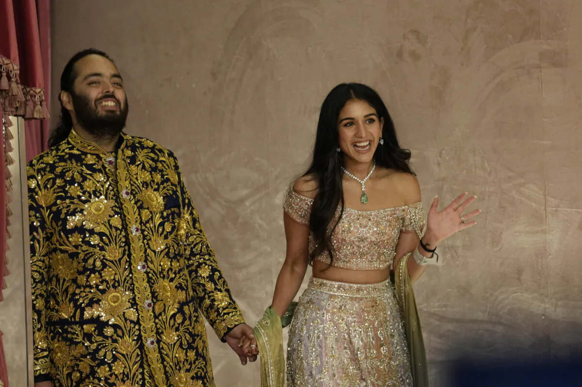 Anant Ambani (L) and Radhika Merchant pose for photographers during their pre-wedding ceremony in Mumbai, India, on July 5, 2024. (Rajanish Kakade/AP Photo)