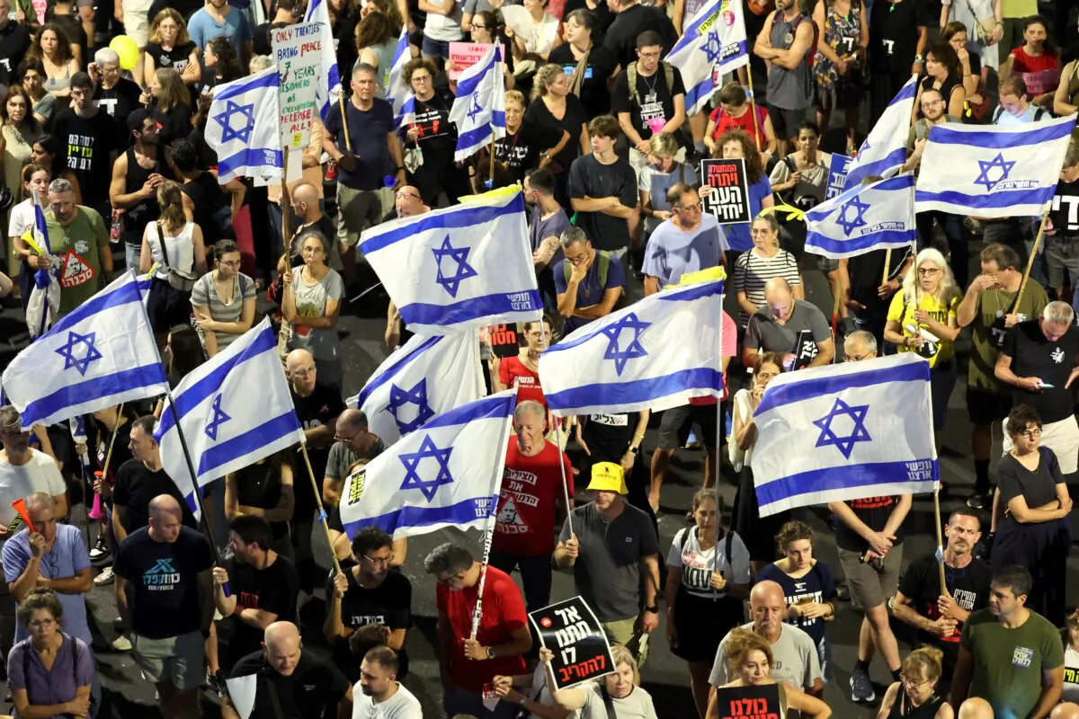 Supporters and relatives of Israelis held hostage by Hamas in Gaza since the Oct. 7, 2023, attacks hold placards and national flags during a demonstration to demand their release in Tel Aviv, Israel, on July 6, 2024. (Jack Guez/AFP via Getty Images)