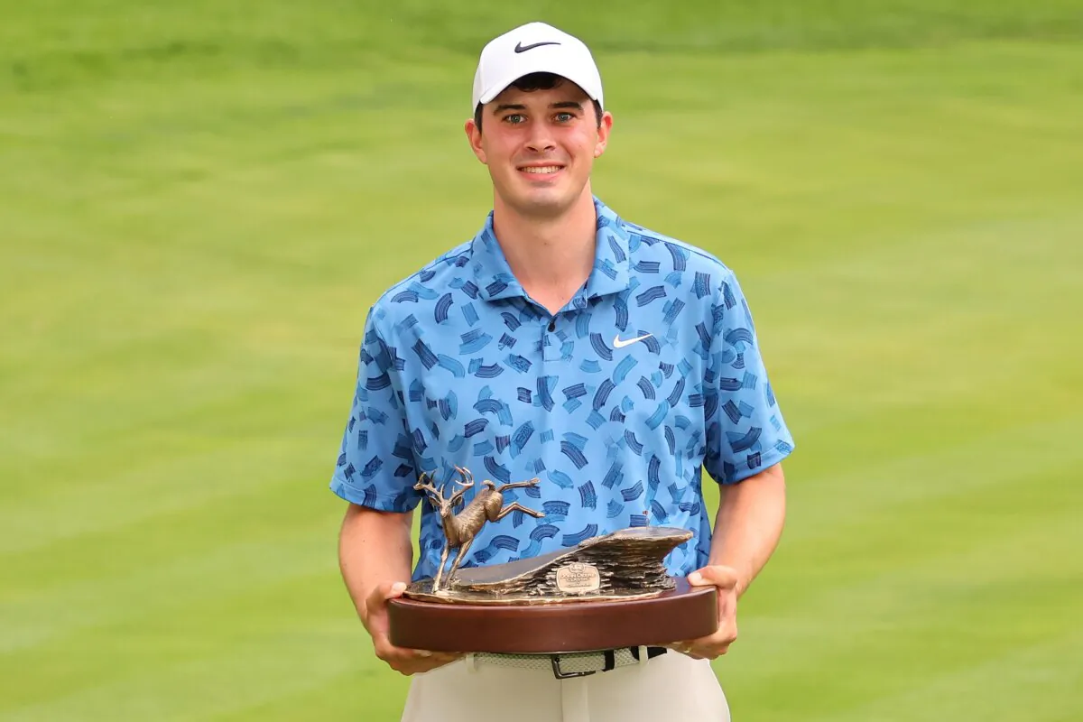 Davis Thompson of the United States celebrates with the trophy after winning the John Deere Classic in Silvis, Ill., on July 7, 2024. (Stacy Revere/Getty Images)