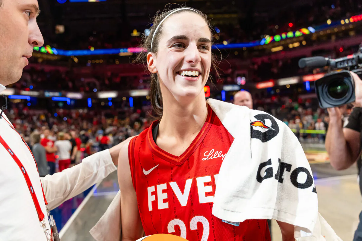 Caitlin Clark #22 of the Indiana Fever is presented the game ball after becoming the first rookie to score a triple double against the New York Liberty at Gainbridge Fieldhouse in Indianapolis, Ind., on July 6, 2024. (Michael Hickey/Getty Images)