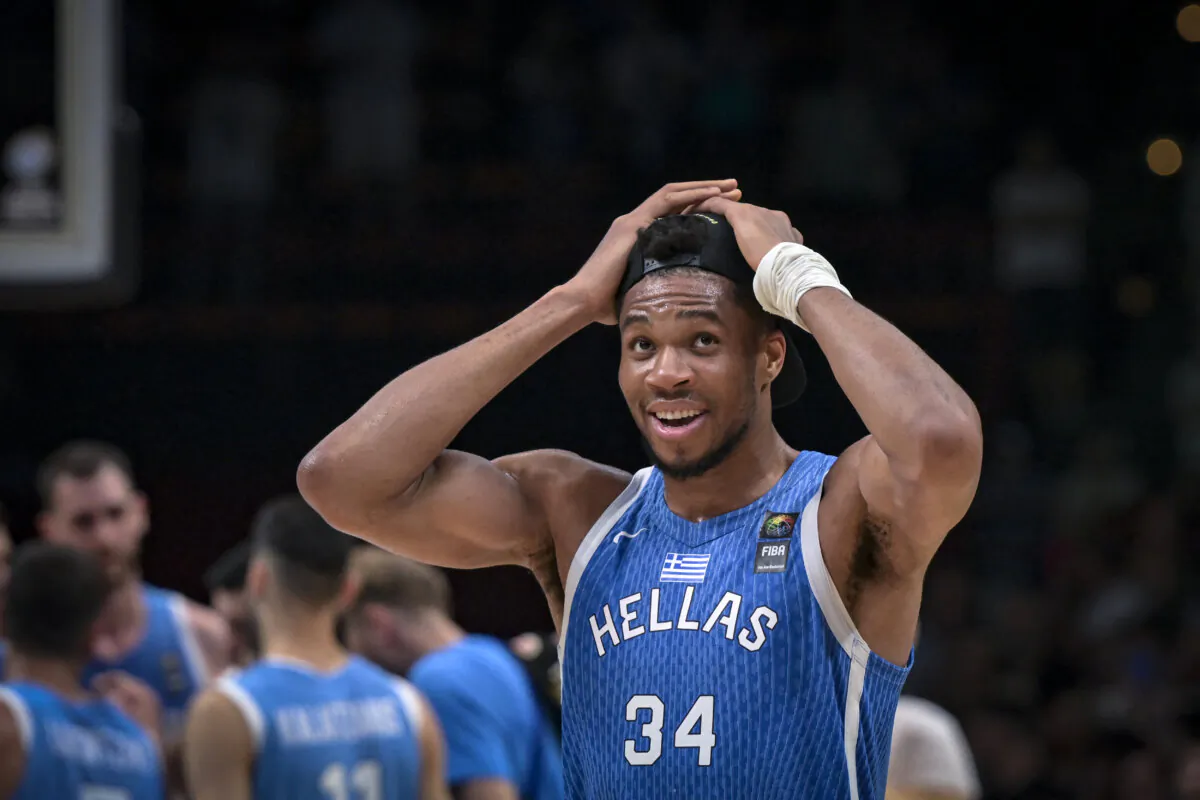 Greece’s Giannis Antetokoumpo puts on a cap as he celebrates the win at the end of the final game of the FIBA Olympic Qualifying Tournament between Croatia and Greece at the Peace and Friendship Stadium in Athens on July 7, 2024. (Aris Messinis/AFP via Getty Images)
