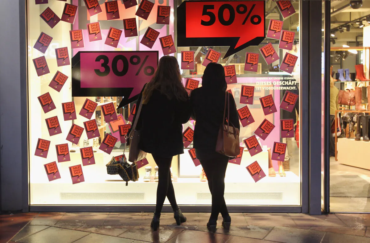 Two young women look at the display window of a shoe store advertising big sales in a file photo. (Sean Gallup/Getty Images)
