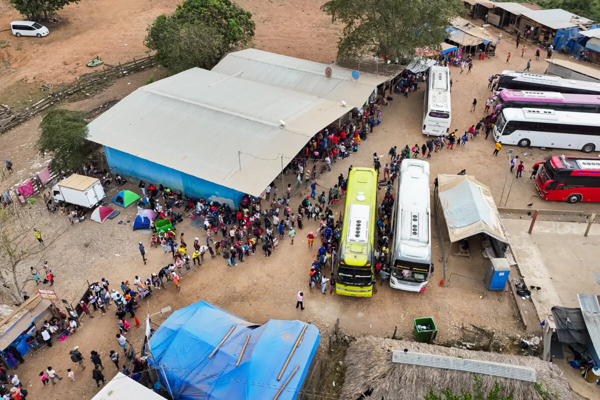 Illegal immigrants who crossed the Darién Gap from Colombia into Panama wait in line for buses into Costa Rica, in the Lajas Blancas migrant camp in Darién, Panama, on July 10, 2024. (The Epoch Times)