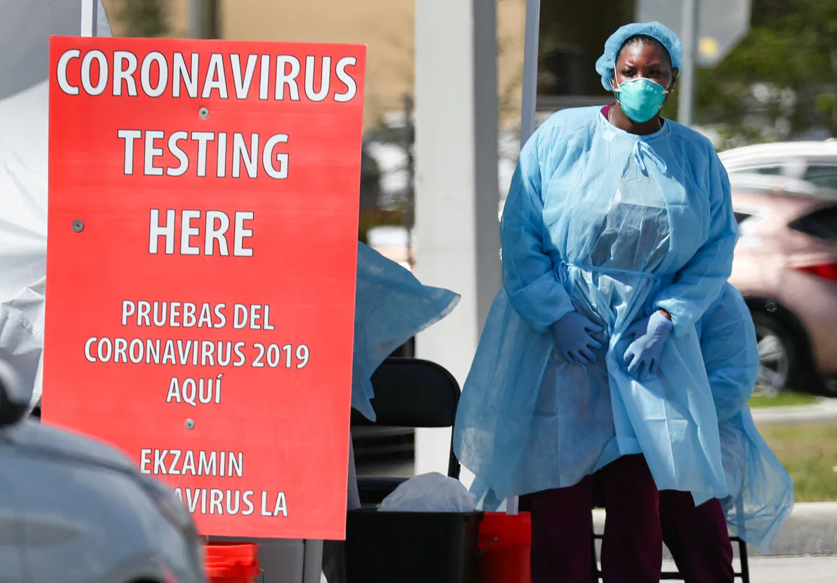 A health care staff member at Community Health of South Florida, Inc. prepares to test people for COVID-19 in the parking lot of its Doris Ison Health Center in Miami on March 18, 2020. (Joe Raedle/Getty Images)