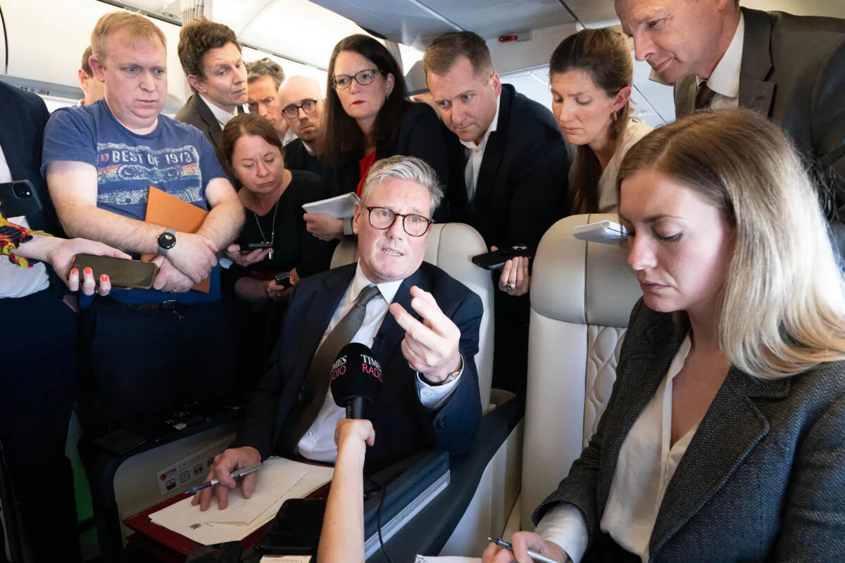Prime Minister Sir Keir Starmer (C) talks to journalists as he travels onboard a plane to Washington to attend a Nato summit, on July 9, 2024. (Stefan Rousseau/PA Wire)