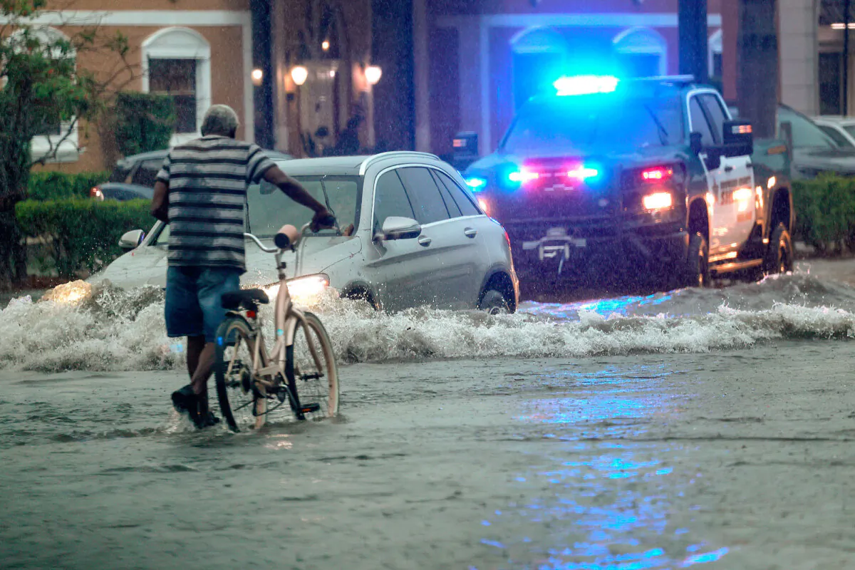 A bicyclist goes through flooded streets on Stirling Road near Federal Highway in Hollywood, Fla., on June 12, 2024. (Mike Stocker/South Florida Sun-Sentinel via AP)