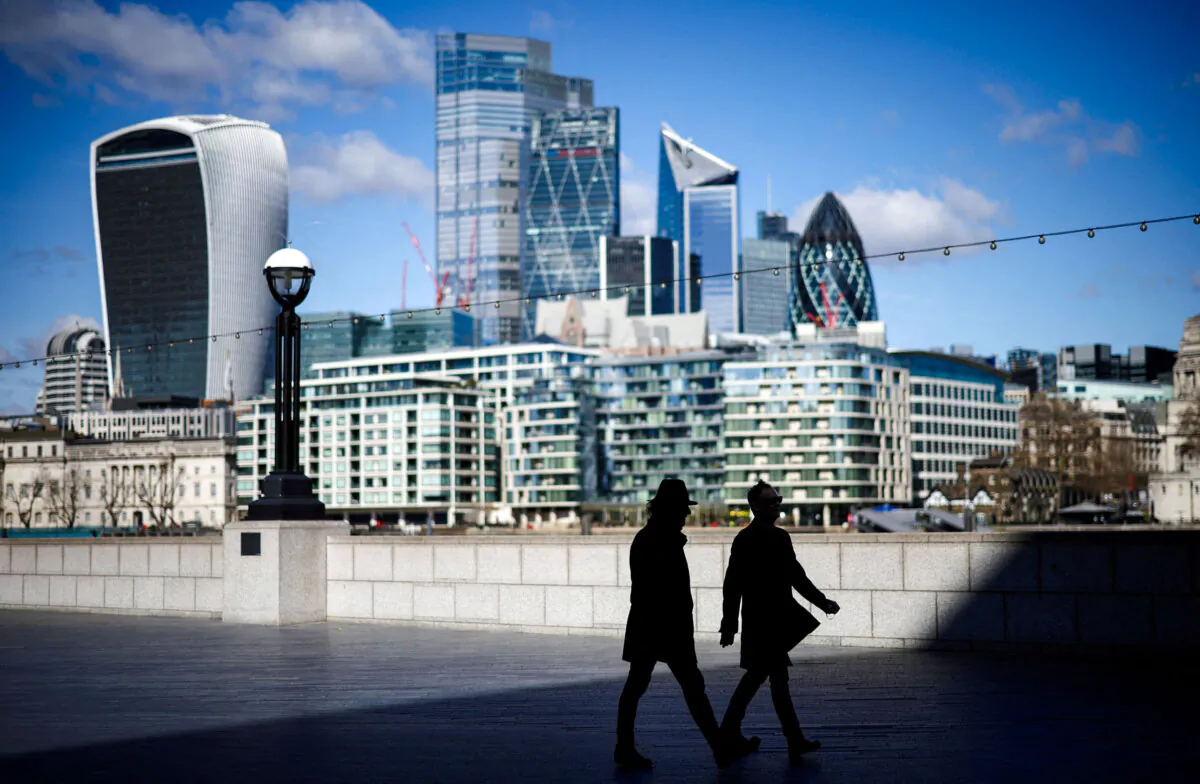 The City of London financial district can be seen as people walk along the south side of the River Thames, in London, on March 19, 2021. (Henry Nicholls/Reuters)