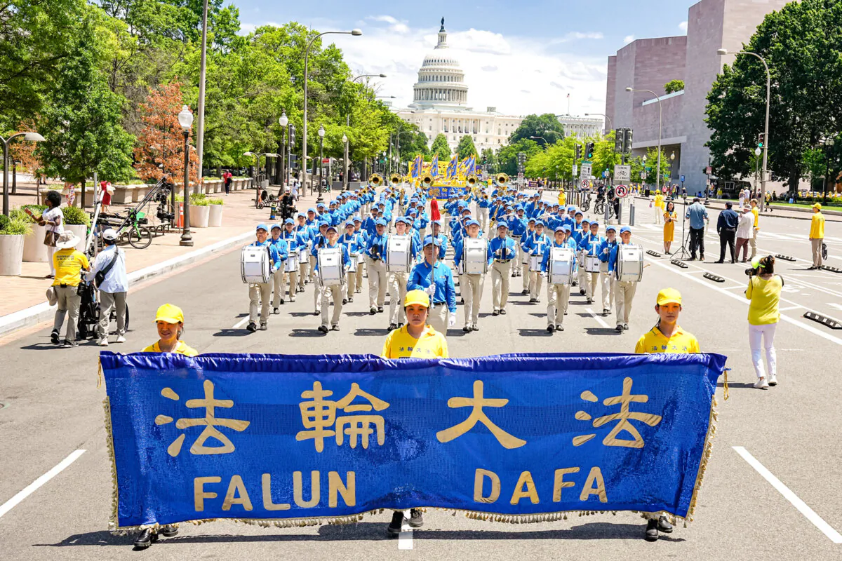 Falun Gong practitioners march during a parade calling for the end of the Chinese Communist Party’s ongoing persecution, now entering its 26th year, at the National Mall in Washington on July 11, 2024. (Larry Dye/The Epoch Times)