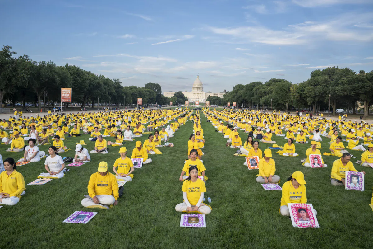 Falun Gong practitioners gather for a candlelight vigil commemorating the persecution deaths of their fellow practitioners in China by the Chinese Communist Party, at the National Mall in Washington on July 11, 2024. (Madalina Vasiliu/The Epoch Times)