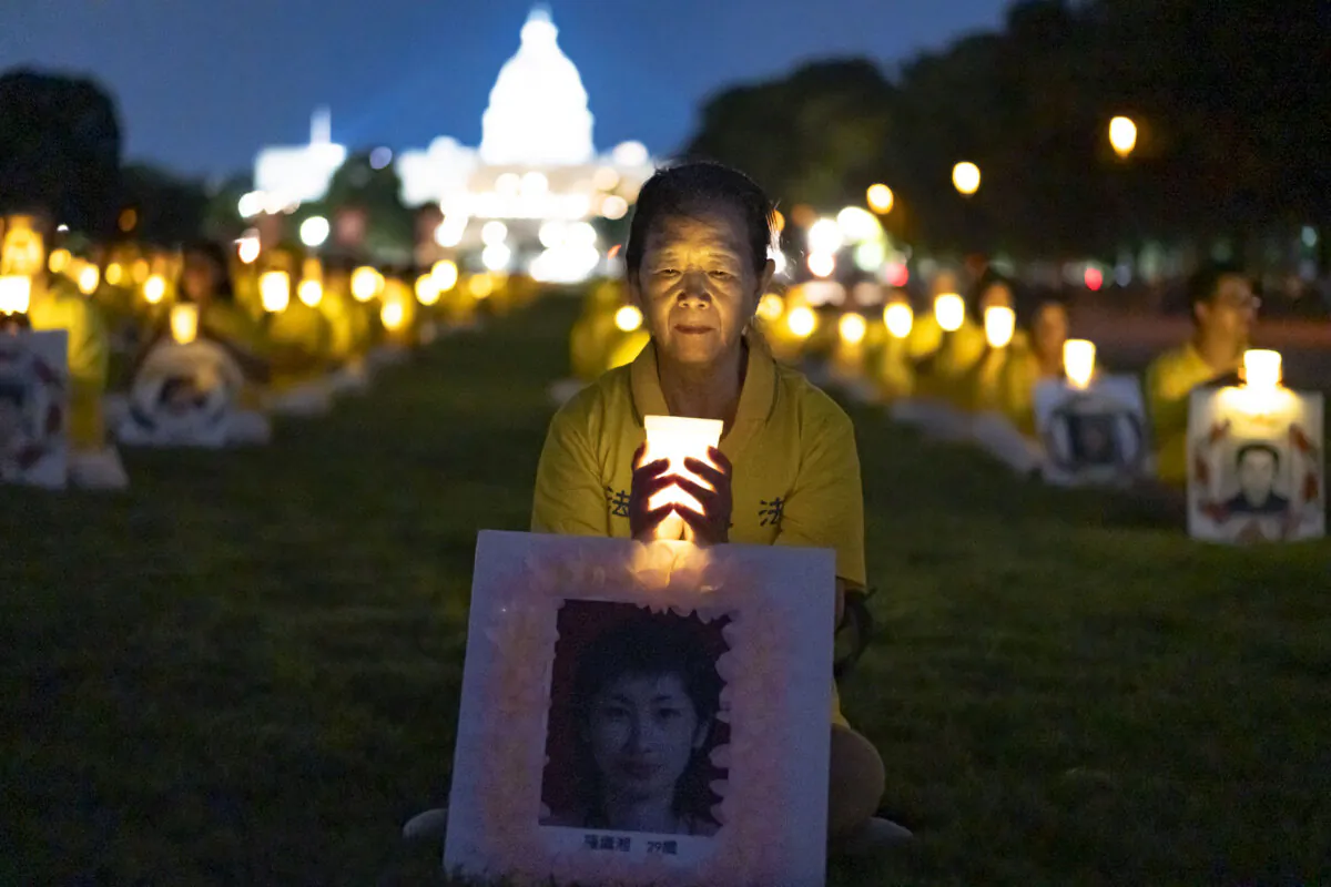 Falun Gong practitioners gather for a candlelight vigil commemorating Falun Gong practitioners’ persecution to death in China by the Chinese Communist Party at the National Mall in Washington on July 11, 2024. (Madalina Vasiliu/The Epoch Times)