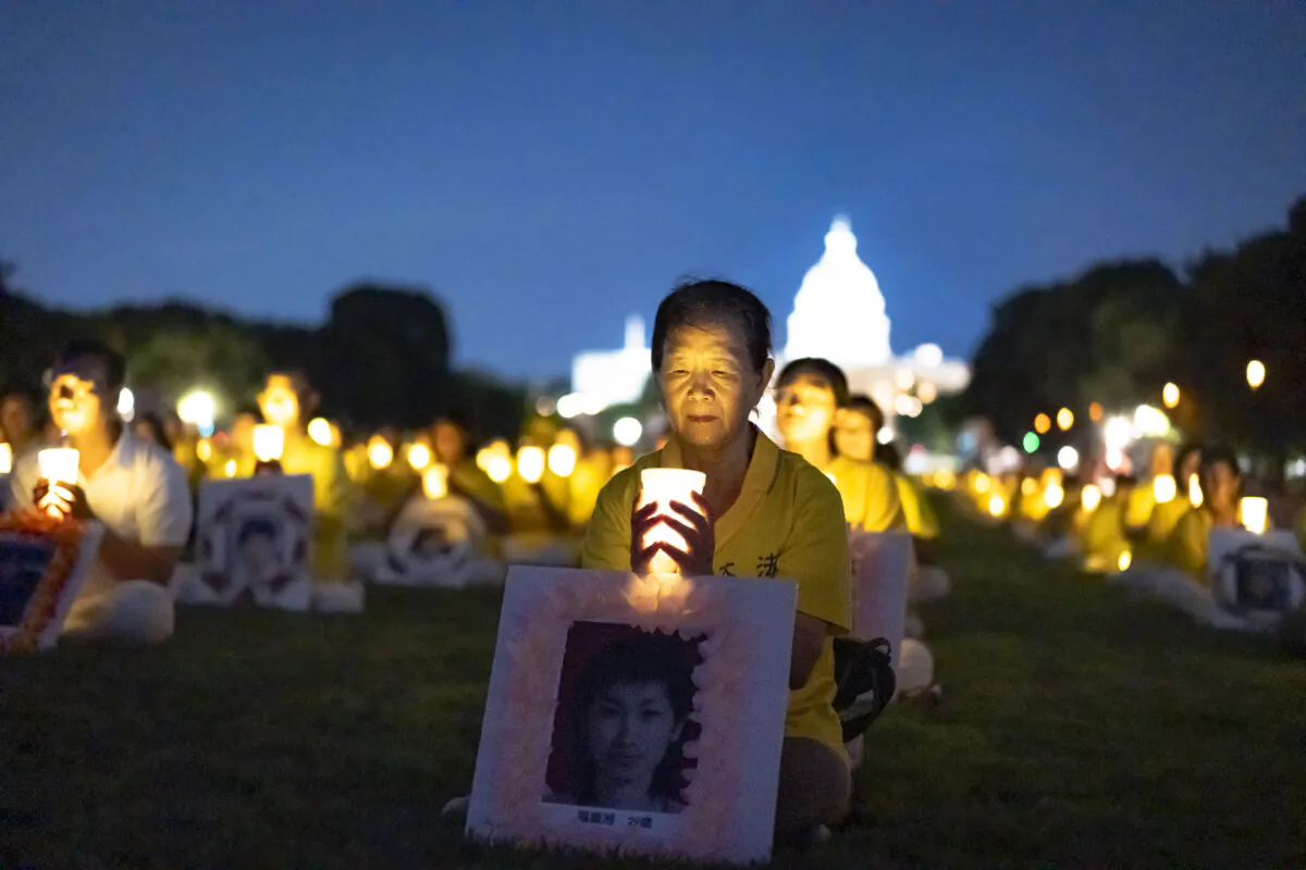 Falun Gong practitioners gather for a candlelight vigil commemorating their fellow practitioners who were killed in China by the Chinese Communist Party, at the National Mall in Washington on July 11, 2024. (Madalina Vasiliu/The Epoch Times)