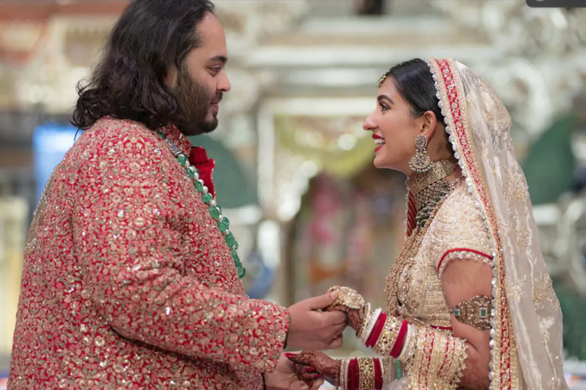 Anant Ambani (L), the son of billionaire Mukesh Ambani, holds hands with Radhika Merchant during their wedding ceremony at Jio World Convention Center in Mumbai, India, on July 12, 2024. (Reliance Industries via AP)