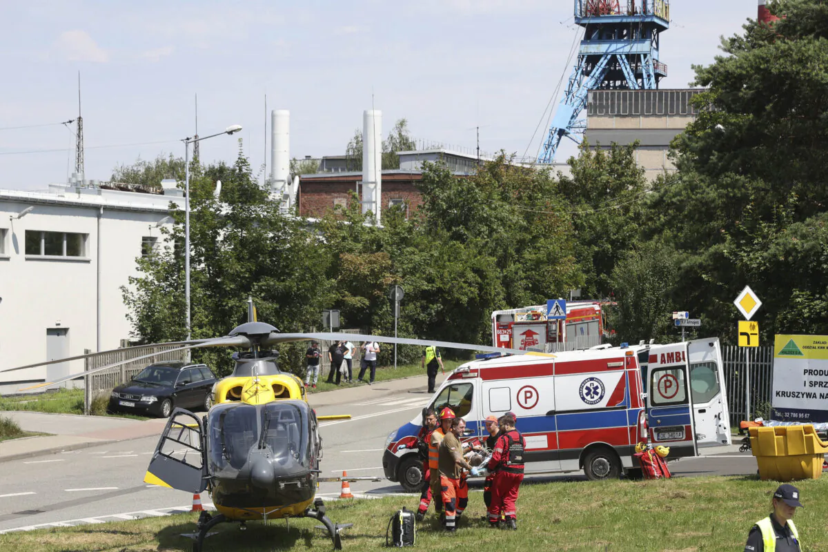 Rescuers transport an injured miner to an airborne ambulance near the Rydultowy coal mine near the city of Rybnik, in southern Poland, on July 11, 2024. (AP Photo/Katarzyna Zaremba-Majcher)