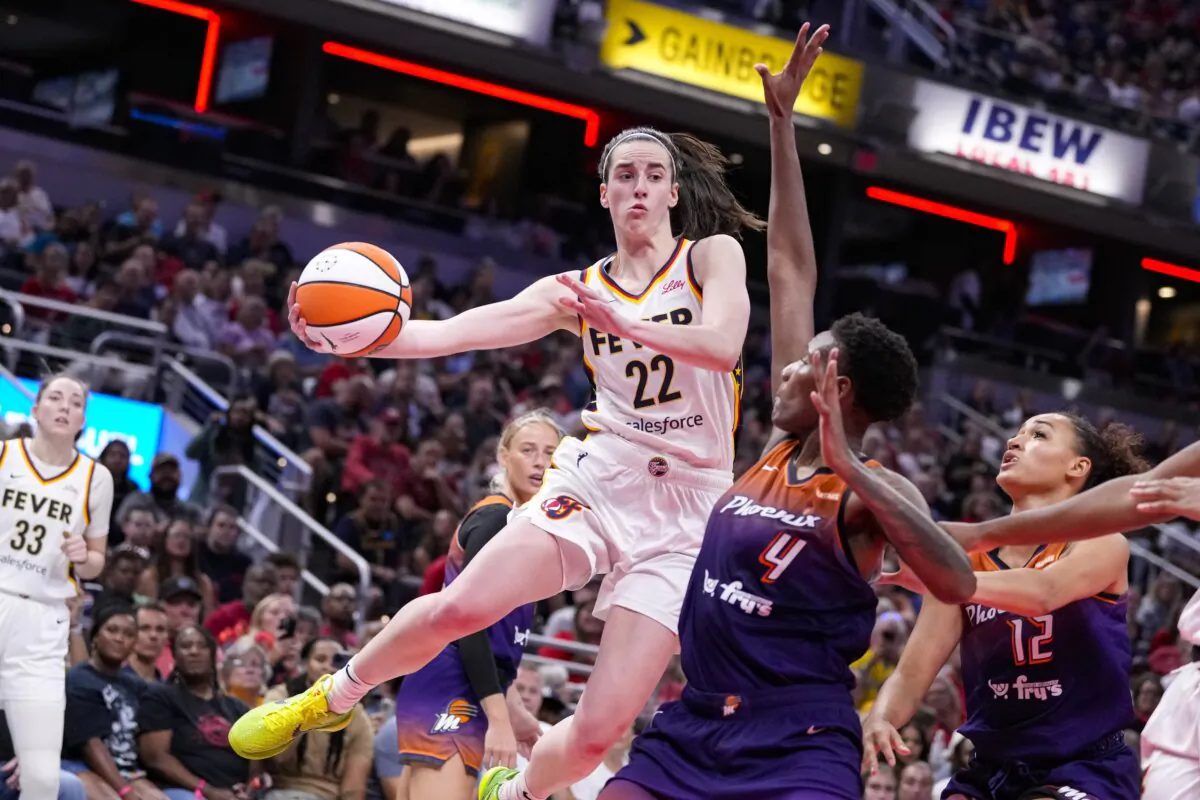 Indiana Fever guard Caitlin Clark (22) makes a pass over Phoenix Mercury forward Natasha Mack (4) in the second half of a WNBA basketball game in Indianapolis on July 12, 2024. (Michael Conroy/AP Photo)