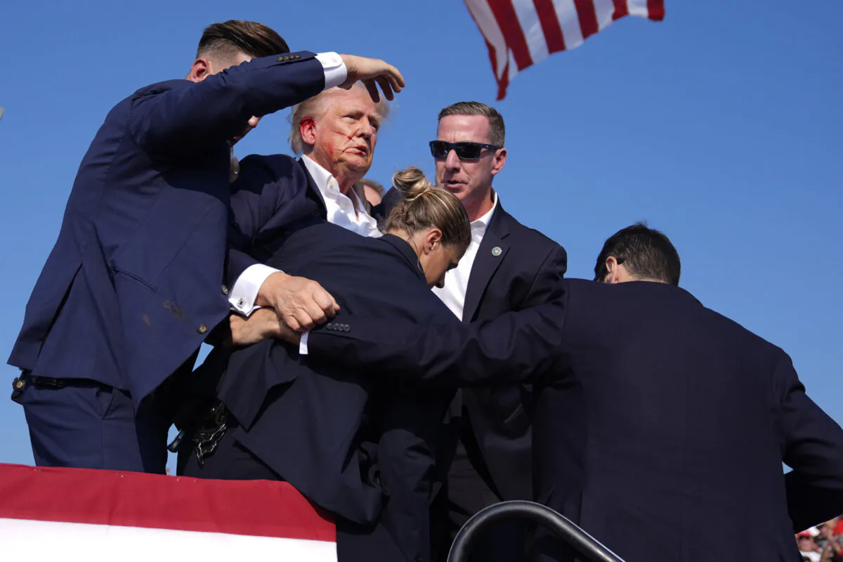 Republican presidential candidate former President Donald Trump is surround by U.S. Secret Service agents after an attempted assassination at a campaign rally in Butler, Pa., on July 13, 2024. (Evan Vucci/AP Photo)