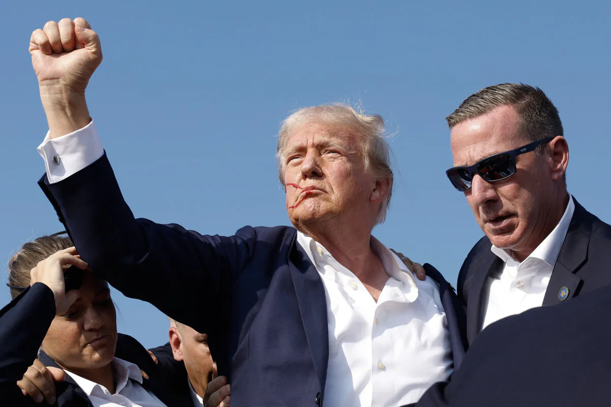 Republican presidential candidate, former President Donald Trump pumps his fist as he is rushed offstage during a rally in Butler, Pa., on July 13, 2024. (Anna Moneymaker/Getty Images)