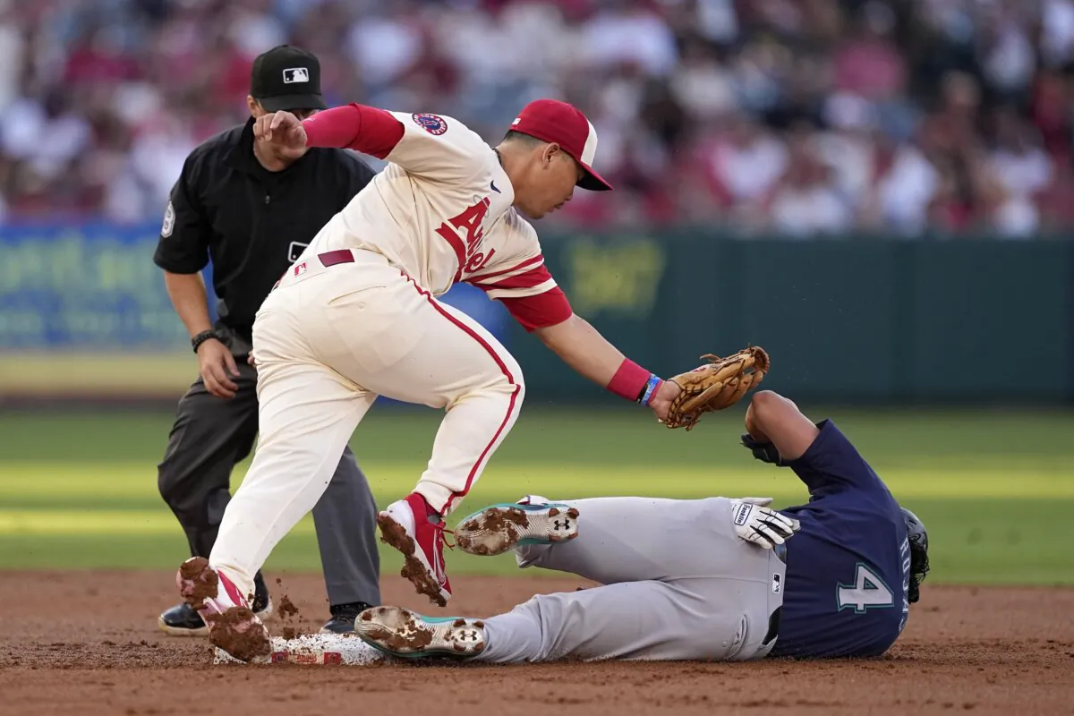Los Angeles Angels second baseman Keston Hiura (C) falls over Seattle Mariners' Josh Rojas aafter tagging him out as he tried to steal second during the second inning of a baseball game  in Anaheim, Calif., on July 13, 2024. (Mark J. Terrill/AP Photo)