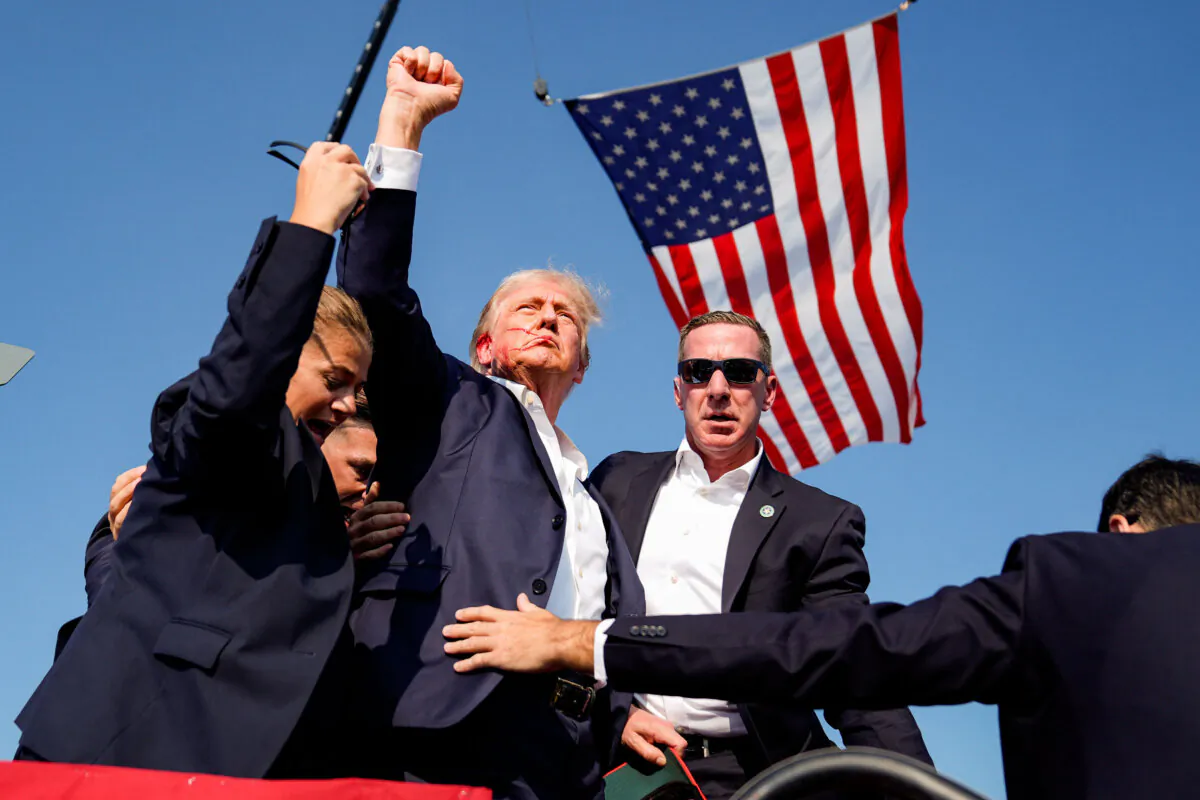 U.S. Secret Service agents rush to protect former President Donald Trump after shots were fired during a campaign rally in Butler, Pa., on July 13, 2024. (Evan Vucci/AP Photo)