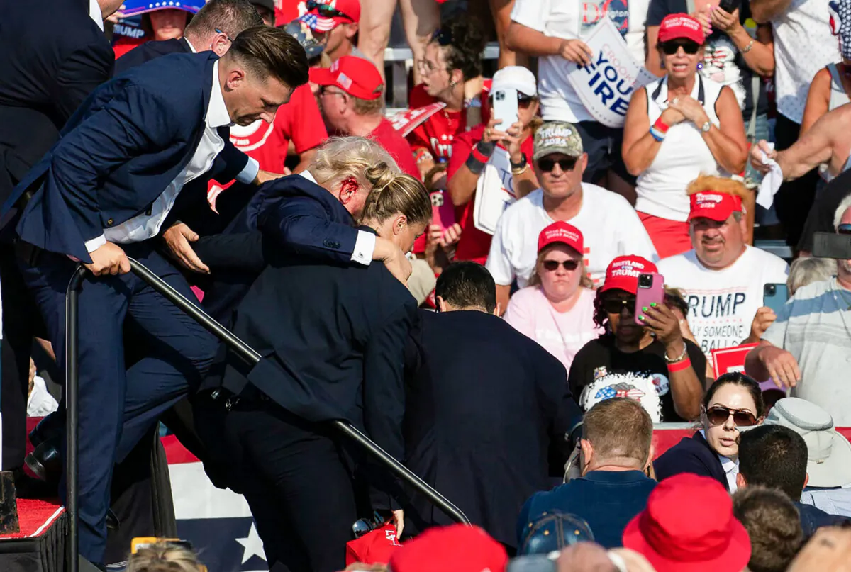 Republican candidate Donald Trump is seen with blood on his face surrounded by secret service agents as he is taken off the stage at a campaign event at Butler Farm Show Inc. in Butler, Pa., July 13, 2024. (Rebecca Droke/AFP via Getty Images)
