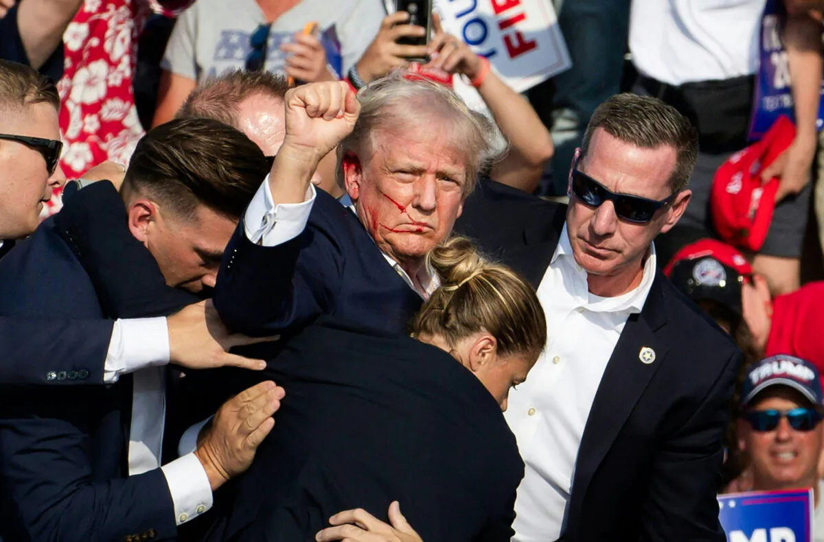 Then-presidential candidate Donald Trump with blood on his face surrounded by secret service agents at Butler Farm Show Inc. in Butler, Pennsylvania, on July 13, 2024. (Rebecca Droke/AFP via Getty Images)