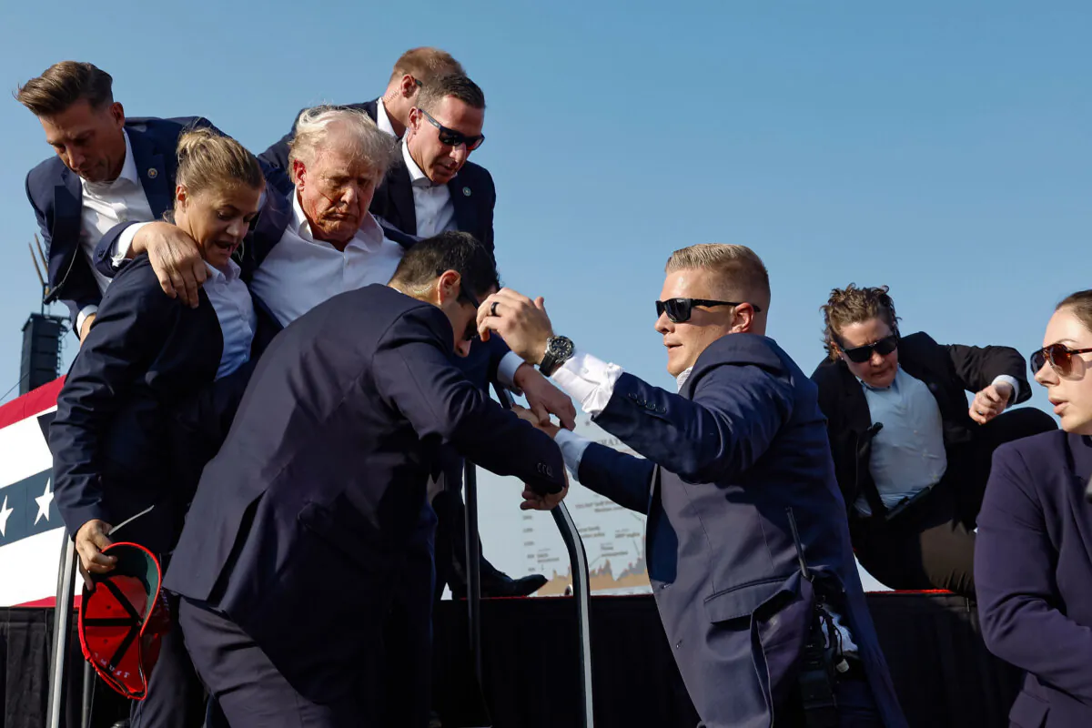 Republican presidential candidate former President Donald Trump is rushed offstage by U.S. Secret Service agents after being grazed by a bullet during a rally in Butler, Pa., on July 13, 2024. (Anna Moneymaker/Getty Images)