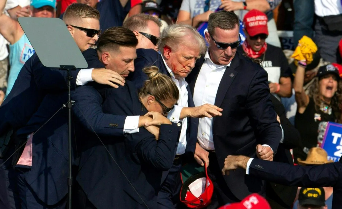 Former President Donald Trump with blood on his face surrounded by secret service agents as he is taken off the stage at a campaign event at Butler Farm Show Inc. in Butler, Pa., on July 13, 2024. (Rebecca Droke/AFP via Getty Images)