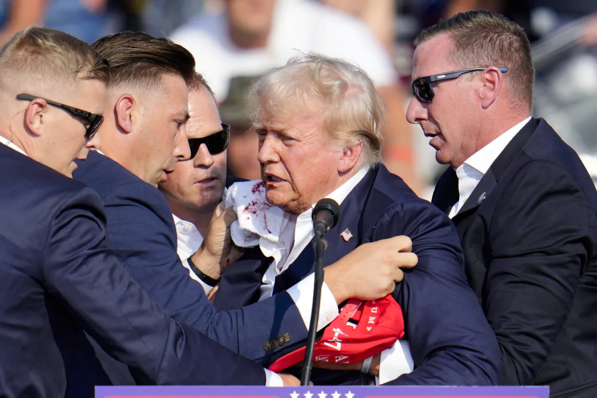 Republican presidential nominee and former President Donald Trump is helped off the stage at a campaign event in Butler, Pa., on July 13, 2024. (Gene J. Puskar/AP Photo)