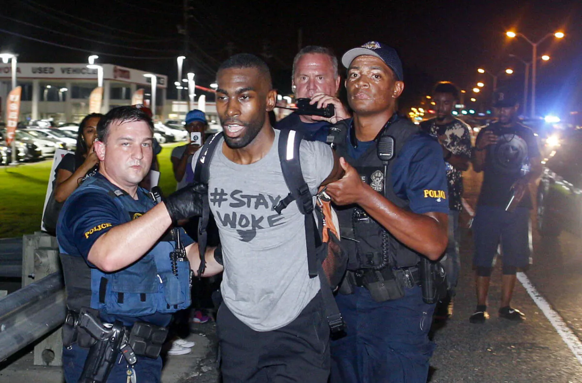 Police arrest activist DeRay McKesson during a protest along Airline Highway, a major road that passes in front of the Baton Rouge Police Department headquarters in Baton Rouge, La., on July 9, 2016. (AP Photo/Max Becherer)