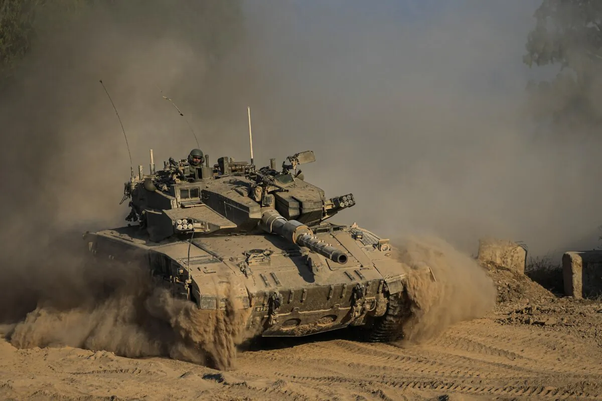 An Israeli soldier moves on the top of a tank near the Israeli-Gaza border, as seen from southern Israel, on July 14, 2024. (Tsafrir Abayov/AP Photo)